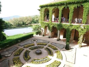 people standing on a balcony of a building with a garden at Hostal El Rincon de la Vera in Losar de la Vera