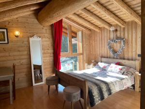 a bedroom with a bed in a wooden room at Chalet Soleil, magnifique triplex sur les pistes in La Rosière