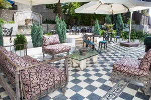 a patio with chairs and tables and an umbrella at Park Plaza Bonaparte Boutique in Santiago