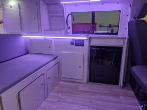 a small kitchen with white cabinets and a mirror at Autocaravana camper Volkswagen gran canaria in Las Palmas de Gran Canaria +5 photos