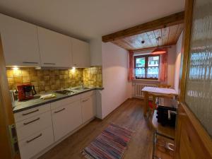 a kitchen with white cabinets and a table and a window at Gästehaus Krumbacher in Bolsterlang