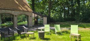 a group of chairs and a table in the grass at Guesthouse Les Buttes in Bruges