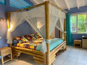 a bedroom with a bed with a canopy at Location privée tout équipé avec petit déjeuner inclus in Le Gosier +53 photos