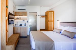 アスプロヴァルタにあるAliston Deluxe Living - Adults Onlyの大きなベッドとキッチンのある寝室