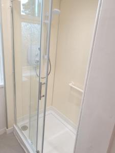 a shower with a glass door in a bathroom at Modern 2-Bedroom Flat Near Park & River in Dumfries +14 photos