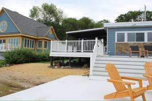a house with a deck and two chairs in front of it at Lakefront Haven on Greenwood Lake in Hewitt
