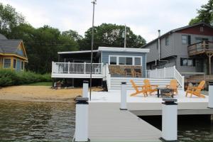 a house on a dock next to the water at Lakefront Haven on Greenwood Lake in Hewitt