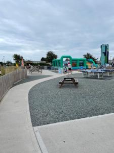 a park with picnic tables and trailers in the background at Snowdrop Caravan in Porthmadog