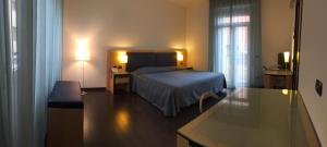 a hotel room with a bed and a desk and a room at Luxury Rooms Padova Station in Padova +16 photos
