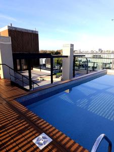 a swimming pool on the roof of a building at Hermoso Departamento en alquiler, Edificio Agora I, Villa Rosa in La Lonja