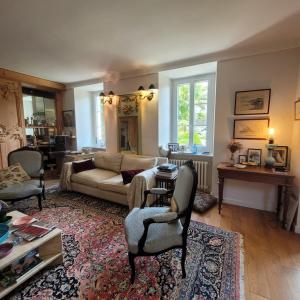 a living room with a couch and a table at Chambres d'Hôtes Maison de Charme à Trégastel in Trégastel