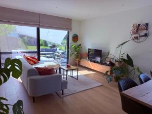 a living room with a couch and a tv at Casa fontanita in Oostduinkerke