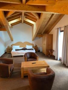 a bedroom with a bed and a table and chairs at Auberge de Savoie in Moutiers