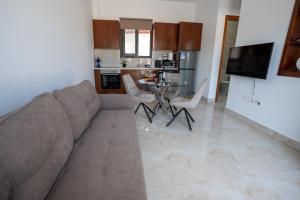 a living room with a couch and a table at ARMA CIELO II, 1-bed Cosy Flat in Paphos