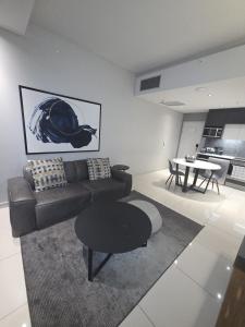 ein Wohnzimmer mit Sofa und Tisch in der Unterkunft ADM Luxury Apartment in Sandton in Johannesburg