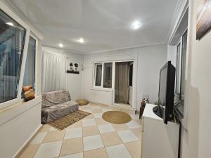 a living room with a television and a couch at Home COLOSSEUM GUEST HOUSE in Bucharest