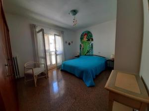 - une chambre dotée d'un lit bleu et d'une peinture murale dans l'établissement La Casetta di Laura, à Badia Morronese