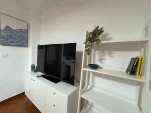 a living room with a tv on a white cabinet at Apartamento Oasis Alamillo in Puerto de Mazarrón