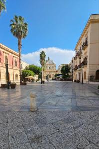 a street in a city with palm trees and buildings at Artista Apartment in Alcamo