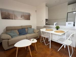 a living room with a couch and a table and chairs at Apartamento Oasis Alamillo in Puerto de Mazarrón