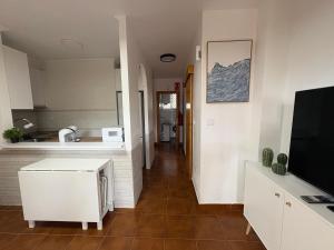 a living room with a kitchen and a television at Apartamento Oasis Alamillo in Puerto de Mazarrón