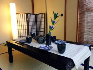 a table with black bowls and vases on it at Du Etowaaru in Nagoya