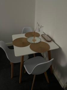 a white table with chairs and a vase on it at Cosy apartment No 2 in Gloucestershire