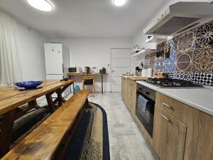 a kitchen with a wooden table and a wooden bench at Home COLOSSEUM GUEST HOUSE in Bucharest