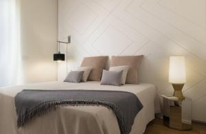 a white bedroom with a bed and a lamp at Villa JD in Forte dei Marmi