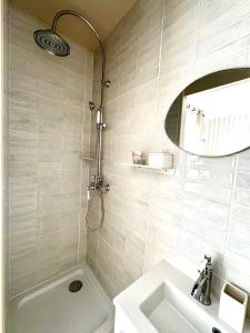 a bathroom with a shower and a sink and a mirror at Le kiosque in Acy-Romance