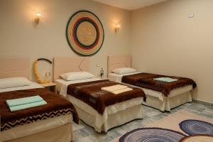 a room with three beds and a mirror at Nour El wadi in Siwa +76 photos