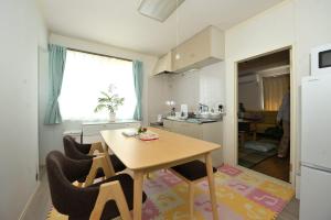 a kitchen with a table and chairs in a room at Stay Chacha 城下町茶茶2F in Marugame