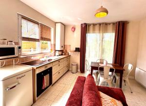 a kitchen with a couch and a table in it at Le kiosque in Acy-Romance