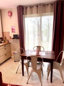 a table and chairs in a kitchen with a window at Le kiosque in Acy-Romance +10 photos