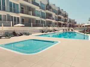 a swimming pool in front of a large apartment building at Poseidon en Playa Arena in Puerto de Santiago