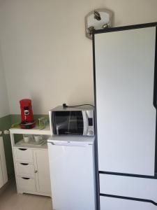 a microwave on top of a refrigerator in a kitchen at Caufour in Lédat