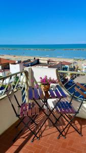 einen Balkon mit 2 Stühlen und einem Blumenkorb in der Unterkunft Casa Stefania Igea Marina Vista Mare in Bellaria-Igea Marina