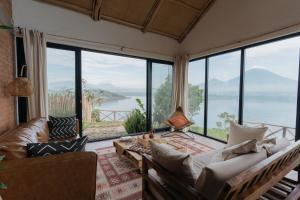 a living room with a couch and large windows at The Writer's Patch in Ruhengeri