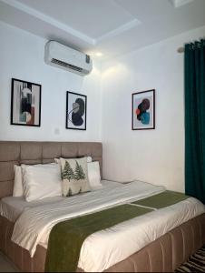 a bedroom with a large bed with green curtains at Woodhaven apartment in Kado