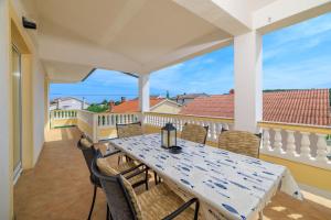 a table and chairs on a balcony with a view of the ocean at Apartments Roby in Kampor