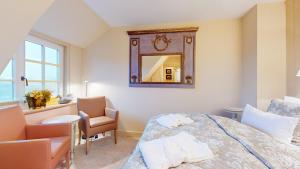 a bedroom with a bed and a mirror and a chair at Oener Reet in Kampen +2 photos