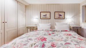a bedroom with a bed with a floral bedspread at Uep Soel in Kampen