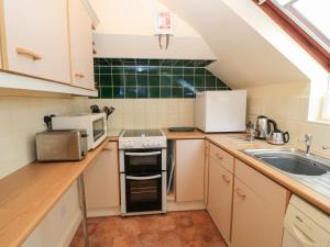 a small kitchen with a stove and a sink at Uplands in Compton +9 photos