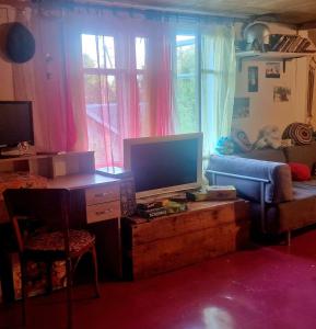 a living room with a television on a wooden table at Puķkalniñš in Ventspils +31 photos