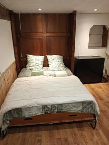 a bed with a wooden headboard in a bedroom at Gîtes citadin avec jardin arboré in Saumur +7 photos