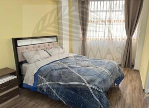 a bedroom with a bed and a window with curtains at Las Palmas Apart in Tacna