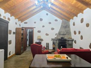 a living room with a table and a fireplace at CR La Montañeta "by henrypole home" in Artenara +25 photos