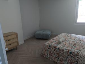 a bedroom with a bed and a ottoman and a dresser at Le petit Ceretan in Céret