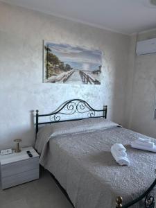 una camera da letto con un letto e un quadro sul muro di Vista D' Amare a Porto Potenza Picena