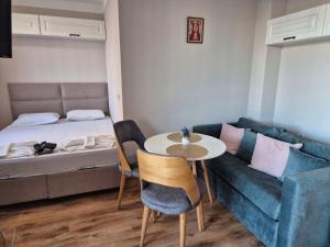 a small room with a bed and a table and a couch at Marea Garden, Ravda - Studio with Pool by Flat Mаnager in Ravda +27 photos